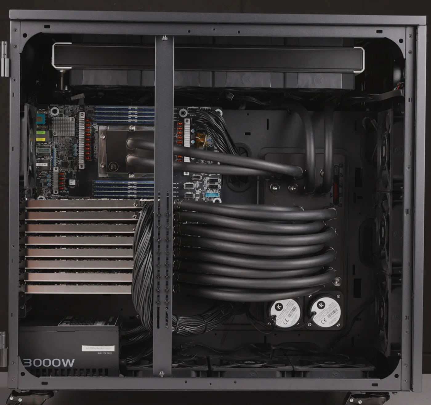 The reference build with its side panel removed: eight GPUs stacked under the CPU water block, the coolant tubing and twin pumps