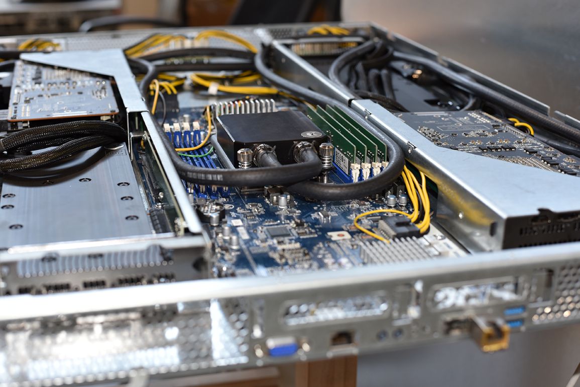 Open 2CRSi server chassis with a liquid-cooled block and its tubing on the motherboard